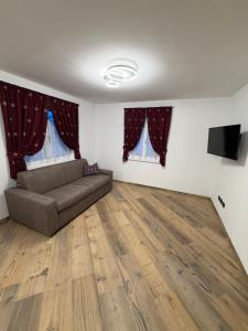 ein Wohnzimmer mit Sofa und Fernseher in der Unterkunft Chalet La Viola in Alba di Canazei