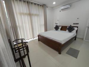 una camera da letto con un letto e una grande finestra di Luxe Diamond Villa a Matara