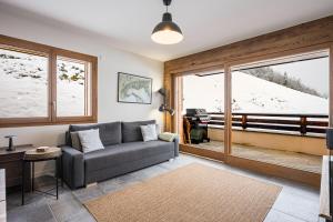a living room with a couch and a large window at Chalet Angelus C201 in Saint-Jean-de-Sixt