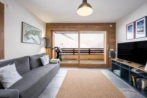 a living room with a couch and a television at Chalet Angelus C201 in Saint-Jean-de-Sixt