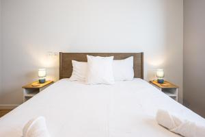 a bedroom with a large white bed with two lamps at Chalet Angelus C201 in Saint-Jean-de-Sixt