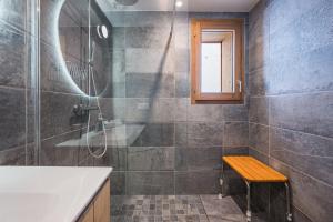 a bathroom with a shower and a sink and a bench at Chalet Angelus C201 in Saint-Jean-de-Sixt +11 photos