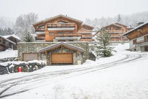 a house in the snow with a snow covered driveway at Chalet Angelus C201 in Saint-Jean-de-Sixt