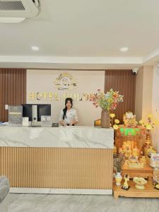 een vrouw aan de balie van een hotel bij Golden Hotel in Ho Chi Minh-stad