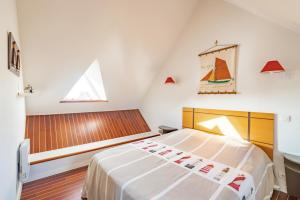 a attic bedroom with a bed and a window at Le Nautic - 5min à pied de la plage in Bénodet +6 photos