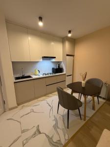 une cuisine et une salle à manger avec une table et des chaises dans l'établissement Ugam revers Apartments, à Khumson