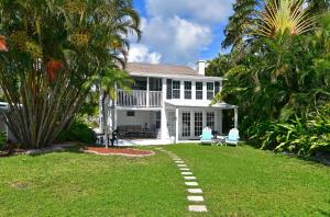 una casa bianca con palme nel cortile di Seaside Serenity a Bradenton Beach