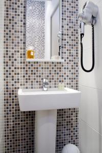 a bathroom with a sink and a mirror and a toilet at Hôtel Du Printemps in Paris