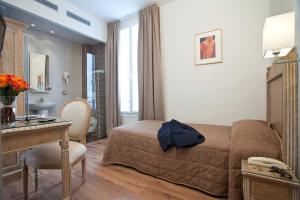 a hotel room with a bed and a desk and a room at Hôtel Du Printemps in Paris