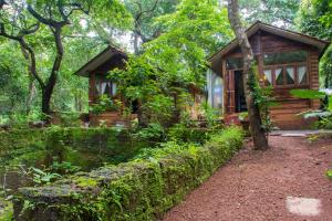 a log cabin in the woods with a garden at Namaste Jungle - A Boutique Homestay in Assagao