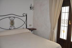 a bedroom with a white bed and a window at Casa de las Remigias in Estepona