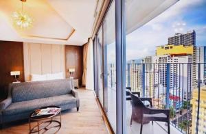 un salon avec un canapé et un balcon dans l'établissement Panorama Nha Trang - San Ocean Breeze Pearl, à Nha Trang