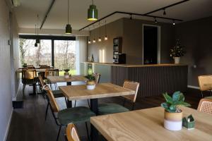 a restaurant with wooden tables and chairs and windows at Zicht op Urk in Urk