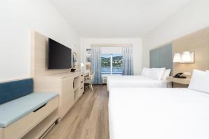 a hotel room with two beds and a flat screen tv at Hampton By Hilton Saint Thomas in Charlotte Amalie