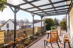 een pergola boven een patio met een tafel en stoelen bij Angie's Ferienapartment in Lichtenfels