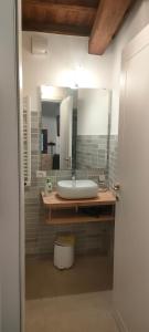 een badkamer met een wastafel en een grote spiegel bij Locanda delle fonti in Bassano in Teverina