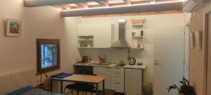 una cucina con mobili bianchi e un tavolo in una stanza di Locanda delle fonti a Bassano in Teverina