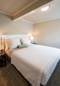 a bedroom with a large bed with white sheets at Beach Drive Suites in Seaside