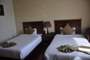 twee bedden in een hotelkamer met bogen erop bij Foyat Hotel in Addis Ababa +7 foto's