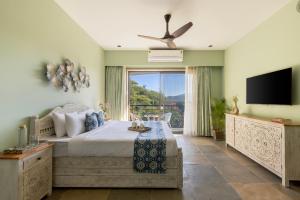 a bedroom with a bed and a flat screen tv at SaffronStays Grand Pavilion in Udaipur
