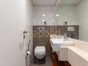a bathroom with a white toilet and a sink at ZAPBED HOUSE -1 BR In Pacific Tower Al Marjan Island With Beach Access Ras Al Khaimah in Ras al Khaimah