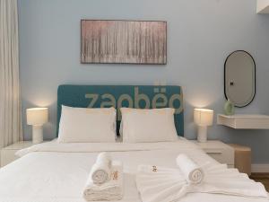 a bedroom with a bed with two towels on it at ZAPBED HOUSE -1 BR In Pacific Tower Al Marjan Island With Beach Access Ras Al Khaimah in Ras al Khaimah