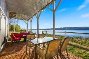 a table and chairs on a patio with a view of the water at Waterfront Walk Out with Private Terrace in Groton +27 photos