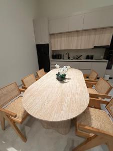 a dining room table with chairs and a vase of flowers at EYZ Lofts By EYZ Holiday Homes in Batroûn +5 photos