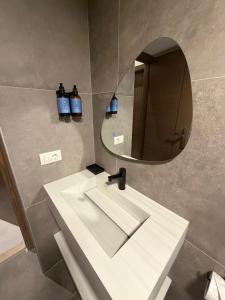 a bathroom with a white sink and a mirror at EYZ Lofts By EYZ Holiday Homes in Batroûn