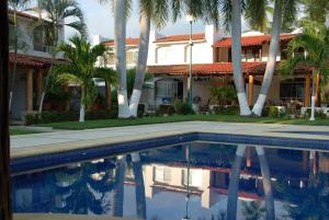 una casa con palmeras y piscina en Casa Romantica De Playa en Ixtapa