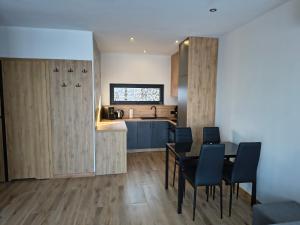 a kitchen and dining room with a table and chairs at Domki nad jeziorem in Dobczyce +16 photos