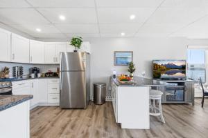 a kitchen with white cabinets and a stainless steel refrigerator at Waterfront Walk Out with Private Terrace in Groton