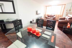 a living room with a glass table with apples on it at Apartment Miraflores Pardo in Lima +28 photos