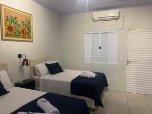 een hotelkamer met twee bedden en een raam bij 103-Quarto Pousada HG in Vila Nova do Sul