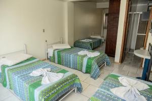 a group of three beds in a room at Hotel Piacenza in Caxias do Sul