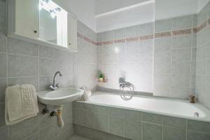 een badkamer met een wastafel en een ligbad bij Anna's view Stegna in Vrachonisída touArchangélou