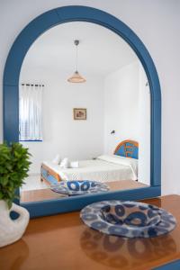 een kamer met een bed en een tafel met een spiegel bij Anna's view Stegna in Vrachonisída touArchangélou