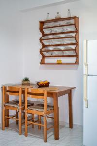 een eettafel met stoelen en een koelkast bij Anna's view Stegna in Vrachonisída touArchangélou