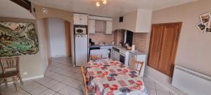 a kitchen with a table and a kitchen with a refrigerator at Les Balcons de Valezan in La Plagne Tarentaise