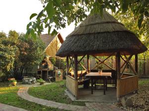a small gazebo with a table in a yard at Natura Vendégház in Pázmánd