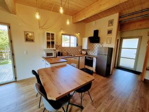 a large kitchen with a wooden table and chairs at Cottage Les Ormeaux - à 13 minutes du Puy du Fou in Les Herbiers +16 photos