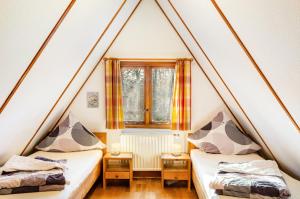twee bedden in een kleine kamer met een raam bij Twistesee Ferienhaus 36 in Wetterburg