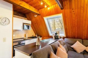 een keuken en een woonkamer met een bank en een klok bij Twistesee Ferienhaus 36 in Wetterburg