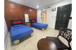 ein Schlafzimmer mit zwei Betten und einer Ziegelwand in der Unterkunft Hotel O Classic Homestay Keningau in Keningau