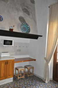 a kitchen with a counter and two stools in it at Casa de las Remigias in Estepona