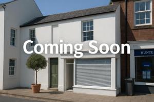 une maison blanche avec un panneau « Ouverture prochaine » dessus dans l'établissement Bridge View Cottages, à Annan