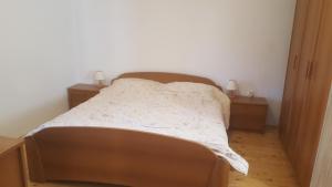 a bed in a room with two night stands and two tables at Kraska hisa in Komen