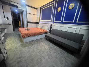een kleine slaapkamer met een bed en een bank bij Fave apartment Nagoya Thamrin in Nagoya
