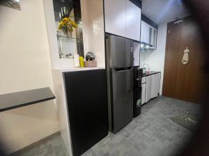 een keuken met een zwarte koelkast in een kamer bij Fave apartment Nagoya Thamrin in Nagoya