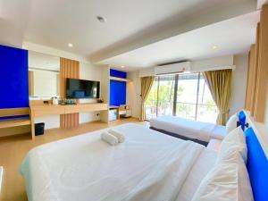 a hotel room with two beds and a television at Armoni Patong Beach Hotel in Patong Beach